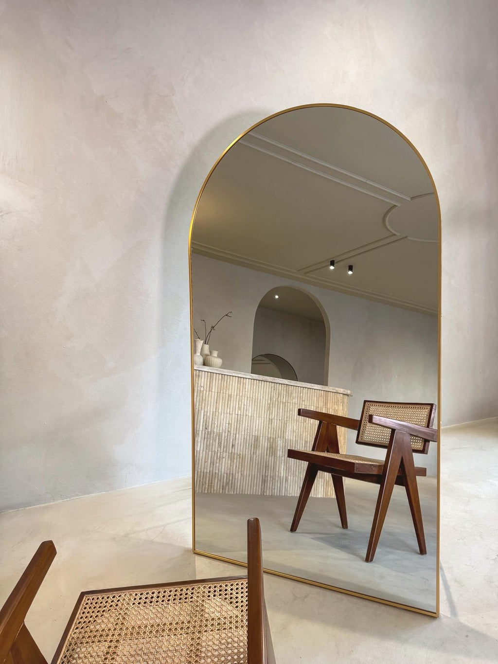ovale staande spiegel goud in woonkamer met houten stoel